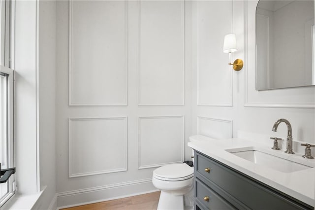 bathroom featuring vanity, toilet, and hardwood / wood-style floors