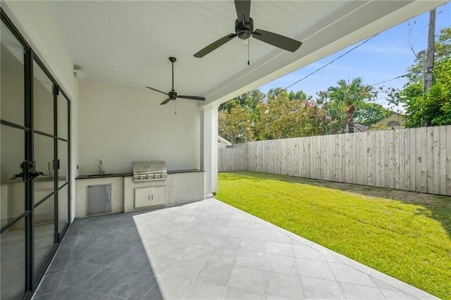 view of patio featuring ceiling fan, an outdoor kitchen, sink, and grilling area