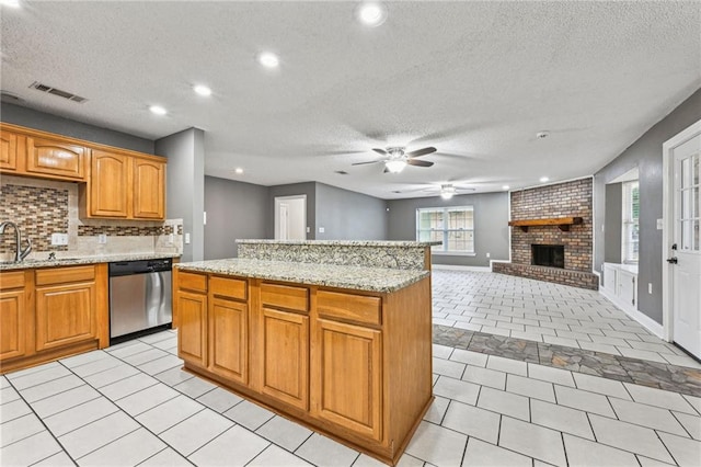 kitchen with light tile patterned flooring, a fireplace, stainless steel dishwasher, and ceiling fan