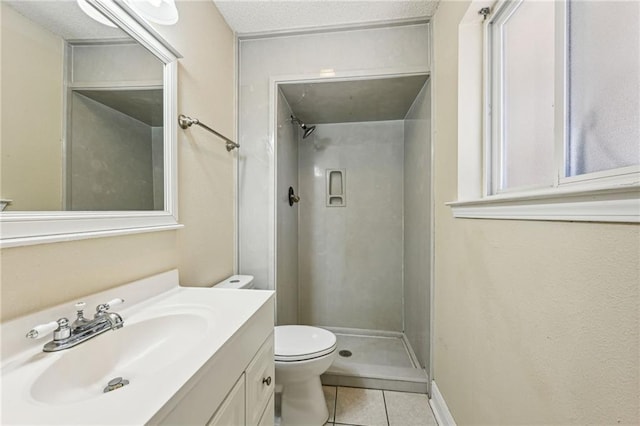 bathroom with a textured ceiling, toilet, vanity, tile patterned flooring, and walk in shower