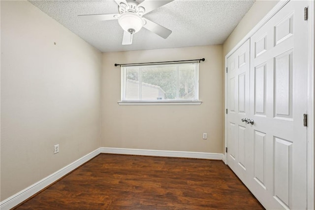 unfurnished bedroom with ceiling fan, dark hardwood / wood-style floors, a textured ceiling, and a closet