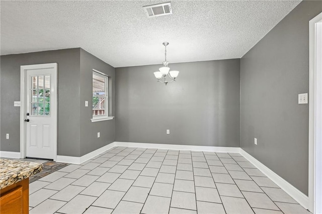 interior space featuring light tile patterned flooring, a textured ceiling, and a chandelier