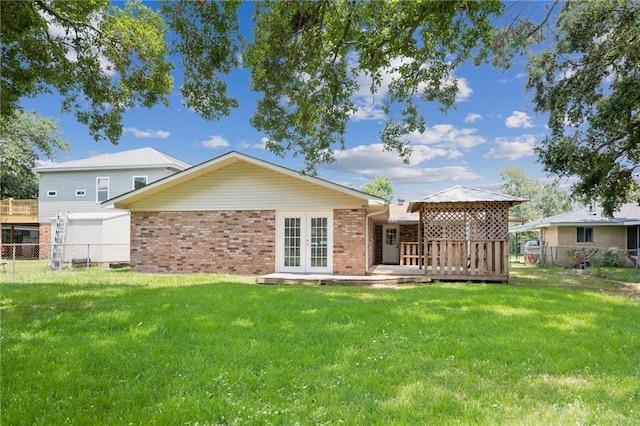 rear view of house with french doors and a yard