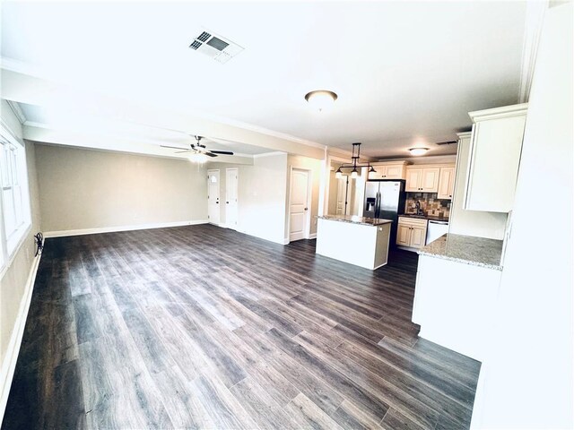 kitchen with ceiling fan, appliances with stainless steel finishes, crown molding, stone countertops, and dark hardwood / wood-style flooring