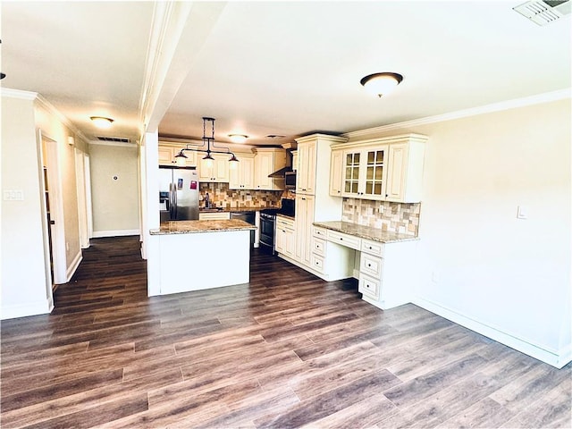 kitchen featuring pendant lighting, stainless steel fridge, range, light stone counters, and a kitchen island