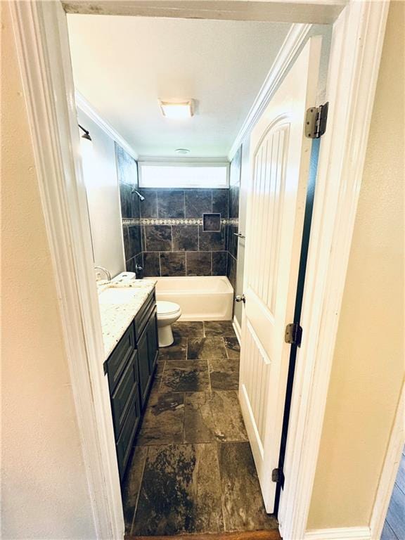 full bathroom with tiled shower / bath combo, vanity, ornamental molding, and toilet