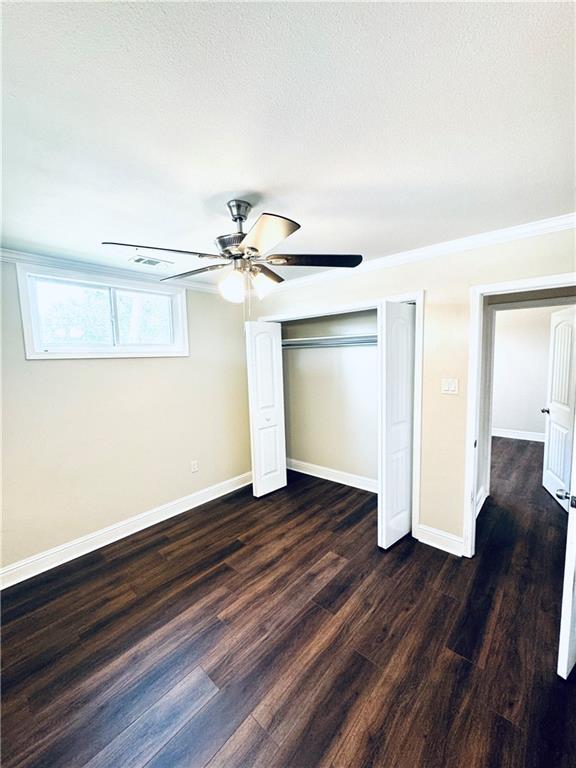 unfurnished bedroom featuring ceiling fan, hardwood / wood-style floors, and a closet