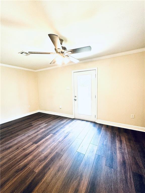 empty room featuring ceiling fan, wood-type flooring, and crown molding