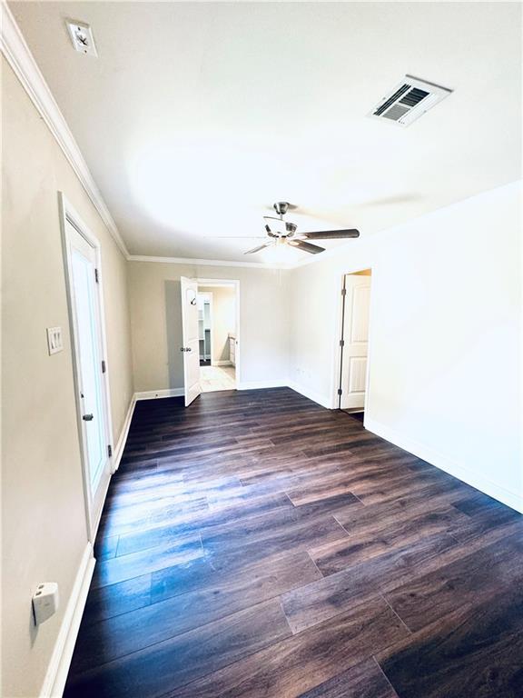 spare room with ceiling fan, crown molding, and dark hardwood / wood-style floors