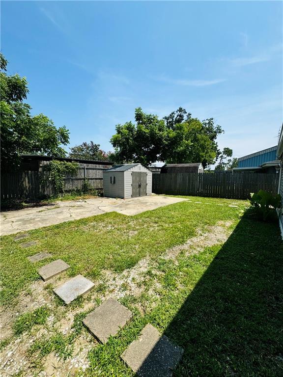 view of yard with a shed and a patio area