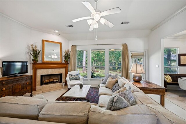 1034 Foy St, Mandeville, LA 70448 - living room with crown molding, ceiling fan, a tiled fireplace, and light tile patterned floors