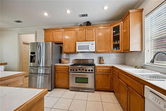 1034 Foy St, Mandeville, LA 70448 - kitchen featuring stainless steel appliances, crown molding, a sink, brown cabinets, and recessed lighting