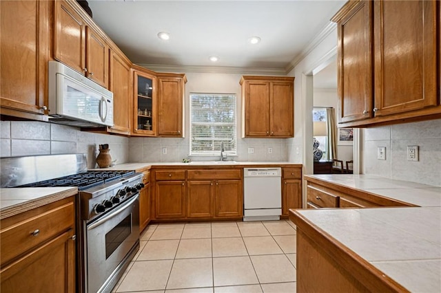 1034 Foy St, Mandeville, LA 70448 - kitchen with white appliances, brown cabinetry, a sink, tasteful backsplash, and ornamental molding
