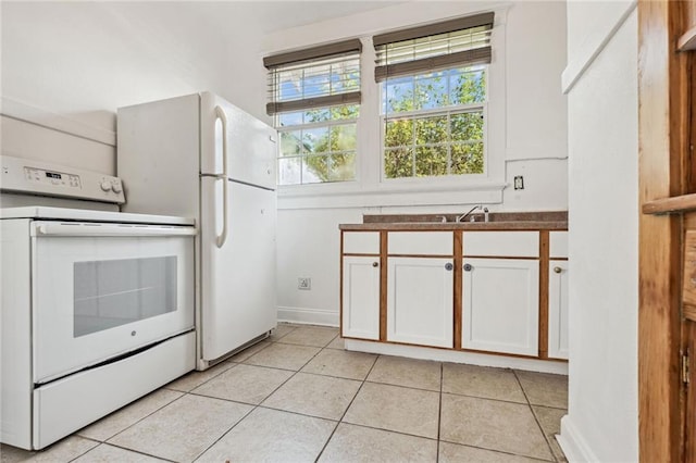 kitchen featuring white appliances, white cabinetry, and light tile patterned floors