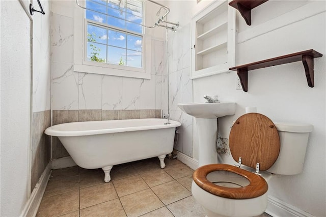 bathroom with a washtub, tile walls, tile patterned flooring, and toilet