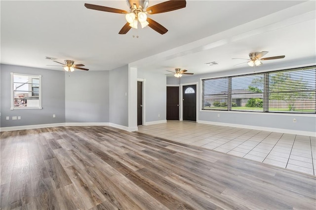 unfurnished living room with light tile patterned floors and ceiling fan