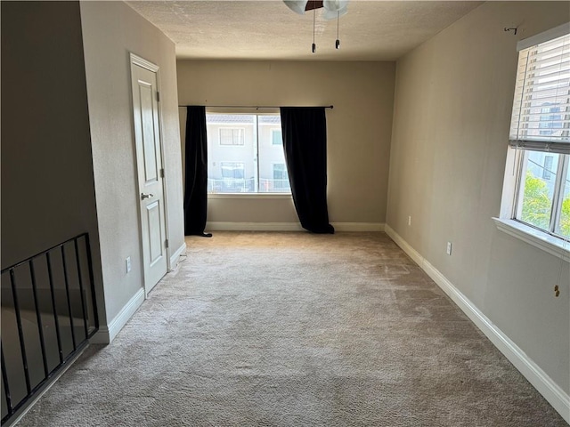 unfurnished room with light colored carpet and a textured ceiling