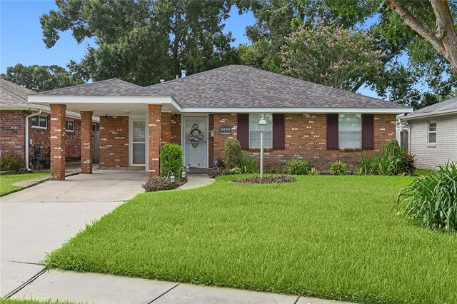 ranch-style house featuring a front yard and a carport