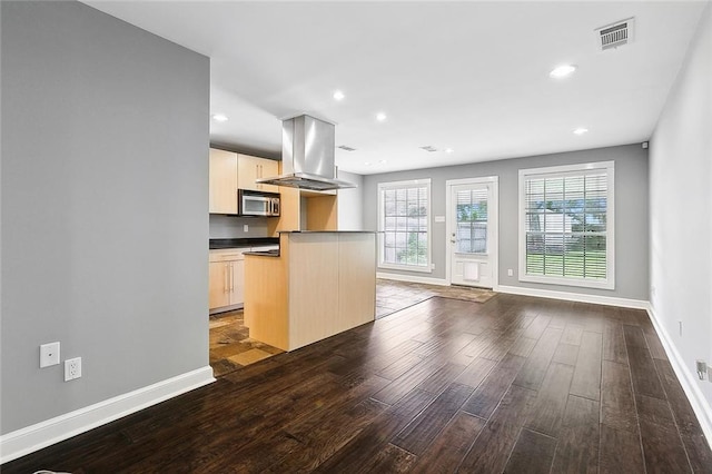 kitchen with island exhaust hood, dark wood-type flooring, a center island, and light brown cabinetry