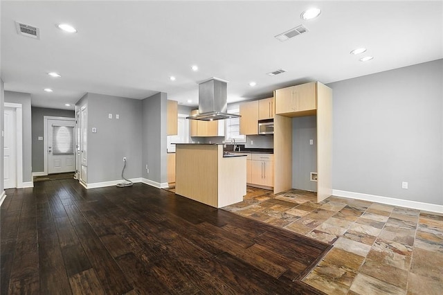 kitchen featuring island exhaust hood, sink, hardwood / wood-style flooring, light brown cabinets, and a center island