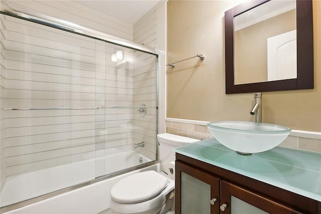 full bathroom featuring shower / bath combination with glass door, vanity, and toilet