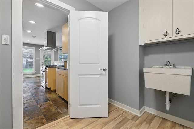 clothes washing area with light hardwood / wood-style flooring