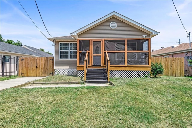 view of front of house featuring a sunroom and a front yard