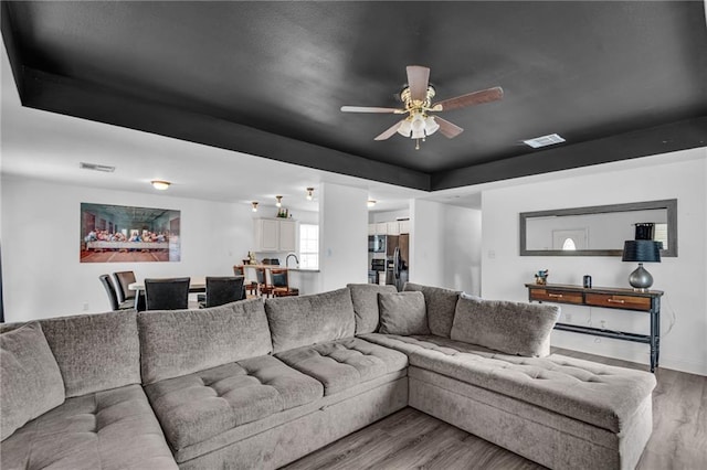 living room featuring ceiling fan and light wood-type flooring