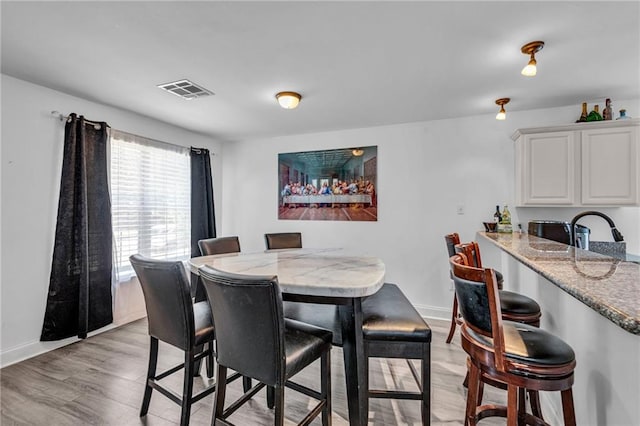 dining space with light hardwood / wood-style flooring and sink