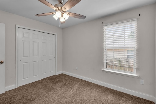 unfurnished bedroom featuring ceiling fan, carpet flooring, a closet, and multiple windows