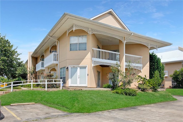 view of front facade featuring a balcony and a front lawn