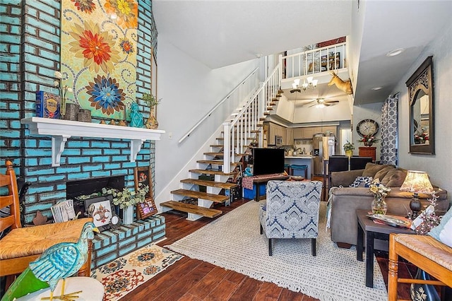 living area featuring stairway, a fireplace, an inviting chandelier, and wood finished floors