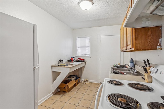 8609 Cohn St, New Orleans, LA 70118 - kitchen with a textured ceiling, under cabinet range hood, light tile patterned floors, white electric range oven, and light countertops