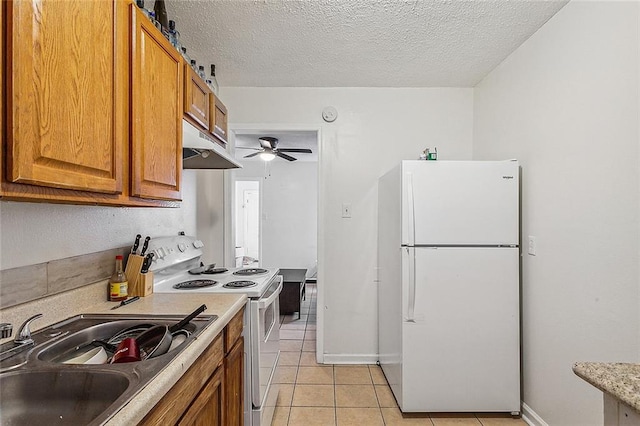 kitchen with a textured ceiling, white appliances, sink, and ceiling fan