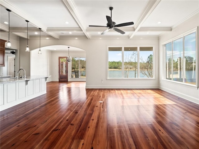 unfurnished living room featuring beamed ceiling, coffered ceiling, dark wood-type flooring, and ceiling fan