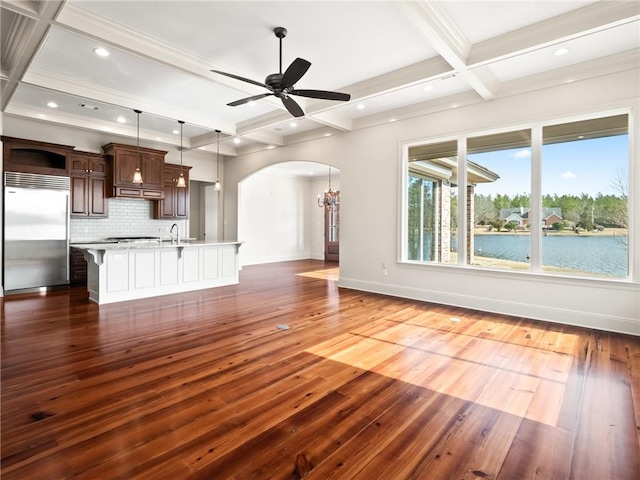 unfurnished living room featuring beam ceiling, sink, ceiling fan, coffered ceiling, and dark hardwood / wood-style floors