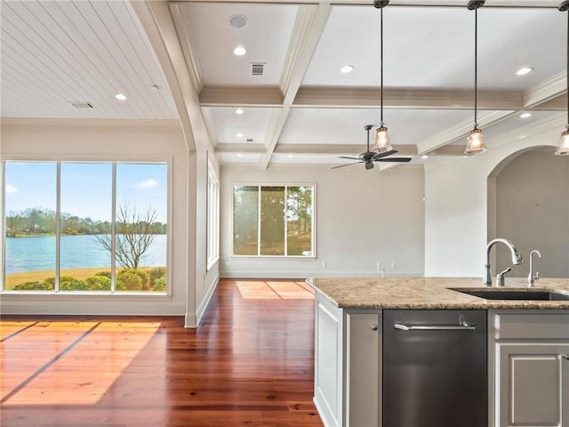 kitchen with coffered ceiling, light stone countertops, wood-type flooring, stainless steel dishwasher, and a water view