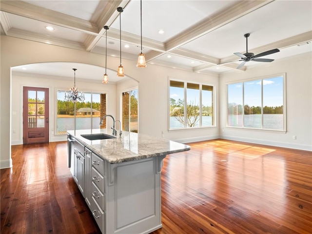 kitchen with coffered ceiling, sink, dark wood-type flooring, and light stone counters