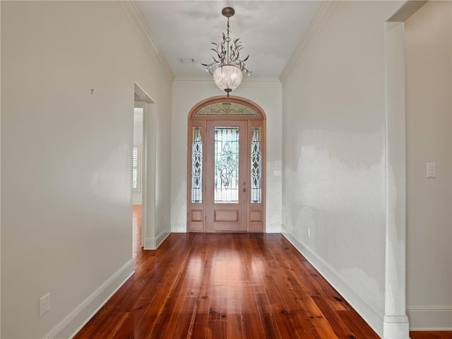 foyer entrance featuring an inviting chandelier, ornamental molding, and wood-type flooring