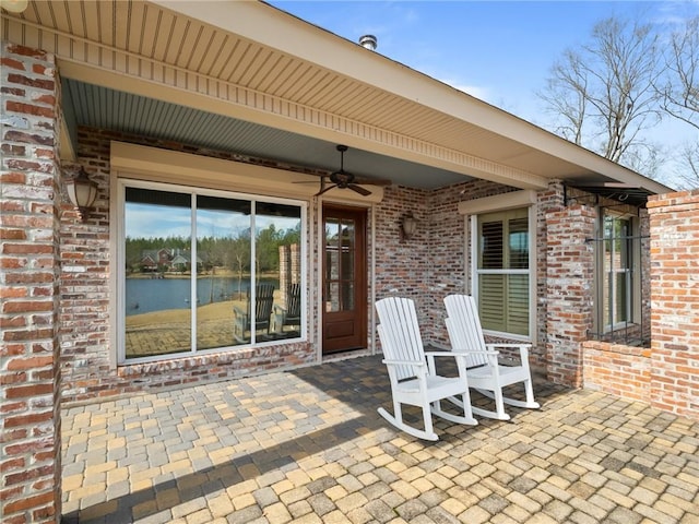 view of patio / terrace featuring ceiling fan and a water view