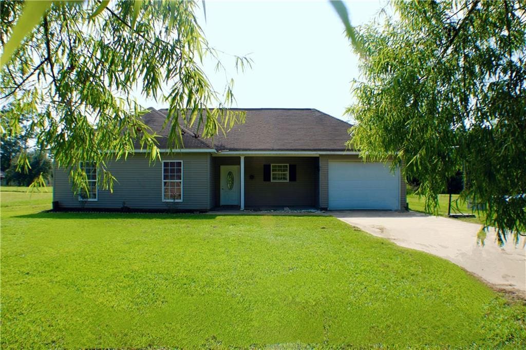 ranch-style house with a garage, driveway, and a front yard