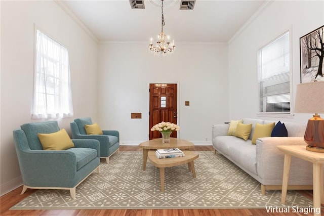 living room with a notable chandelier, wood-type flooring, ornamental molding, and a wealth of natural light