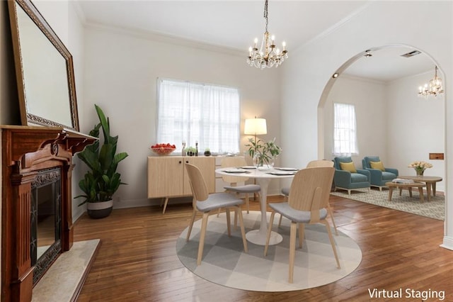 dining area with ornamental molding, dark wood-type flooring, and a healthy amount of sunlight