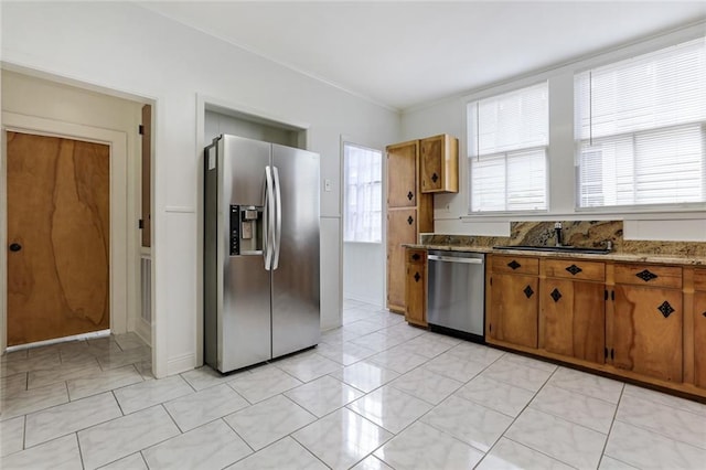 1104 Monroe St, Gretna, LA 70053 - kitchen with appliances with stainless steel finishes, brown cabinetry, ornamental molding, light marble finish flooring, and stone countertops