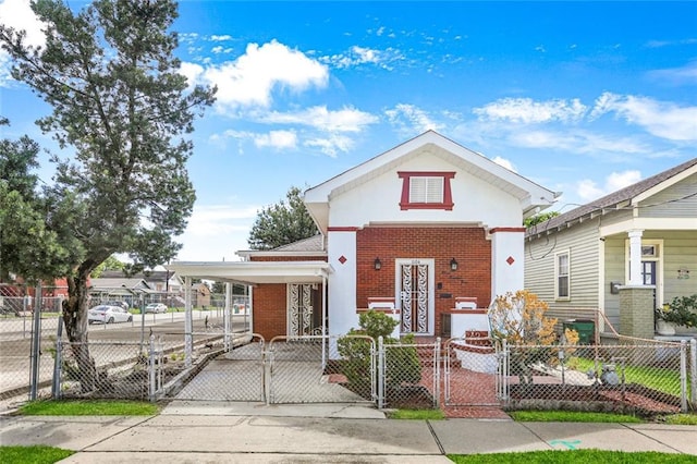 1104 Monroe St, Gretna, LA 70053 - view of front facade with a gate, a fenced front yard, brick siding, driveway, and an attached carport