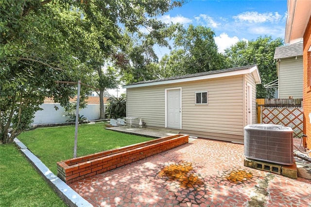 view of yard featuring a patio, cooling unit, and an outbuilding