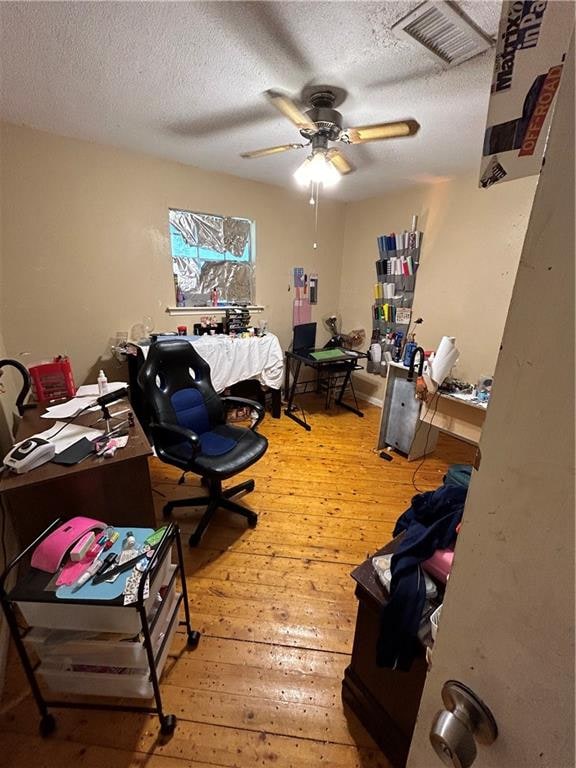 office with ceiling fan, light hardwood / wood-style flooring, and a textured ceiling