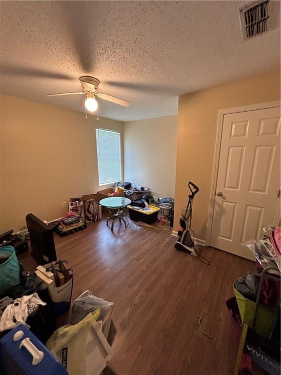 misc room with ceiling fan, wood-type flooring, and a textured ceiling