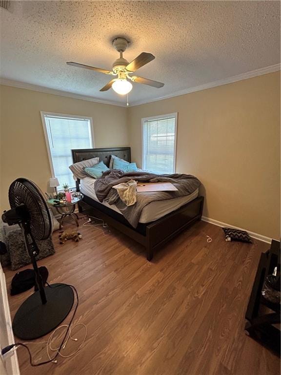 bedroom with ceiling fan, a textured ceiling, ornamental molding, and hardwood / wood-style floors