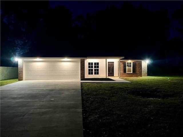 view of front of property with a garage and a yard